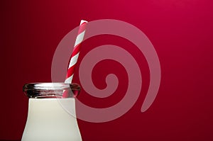 Glass of milk on red background