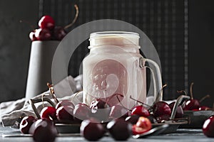 A glass of milkshake with cherries.