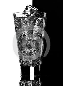 Glass of mineral carbonated water with ice.Black and white background