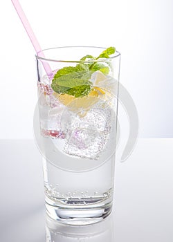 A glass of mineral water decorated with a slice of orange and mint