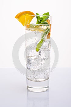 A glass of mineral water with an orange slice and mint