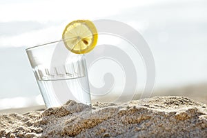 A glass of mineral water for refreshment on sand