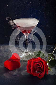 Glass of mistic drink, rose and box with a ring