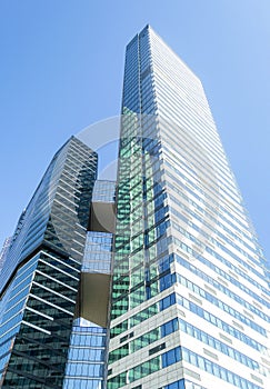 Glass modern skyscraper buildings opposite blue sky