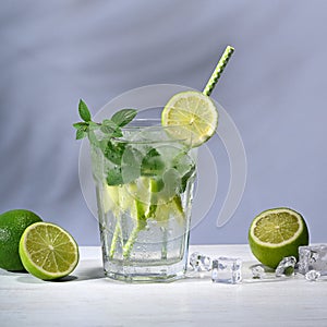 Glass with mojito cocktail and limes