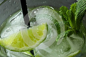 Glass of mojito cocktail with straw, close up