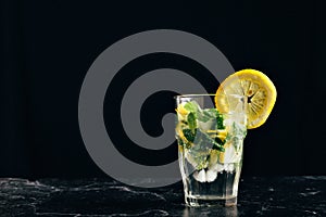 glass of mojito decorated with a lemon on a dark background. close horizontal picture