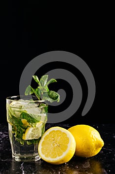 glass of mojito decorated with a sprig of mint and lemons on a dark background. close horizontal picture