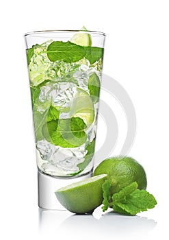 Glass of Mojito summer alcoholic cocktail with ice cubes mint and lime on white with raw lime and mint leaf