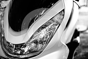 Glass motorcycle headlight. Graceful lines. Front view. Black and white photo