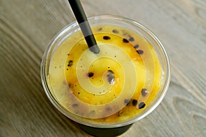Glass of Mouthwatering Mango with Passion Fruit Smoothie on Wooden Table