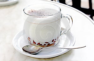 A glass mug with chocolate and milk