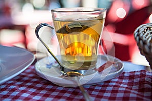 Glass mug with fresh and delicious afternoon tea on a table