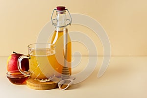 Glass Mug of Fresh Organic Apple Cider with Honey and Cinnamon Yellow Background Horizontal Copy Space