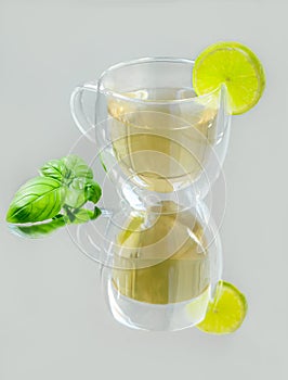 A glass mug of green tea and a slice of lime