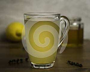 Glass Mug of Hot Lemon, Honey and Ginger Drink with sprigs of Thyme as a cold remedy