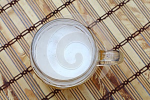 Glass mug of unfiltered weizen beer on table