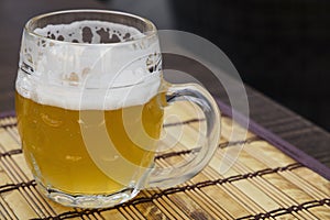 Glass mug of unfiltered weizen beer on table photo