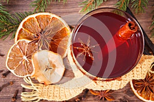 Glass of mulled wine wrapped scarf, spices and spruce branches