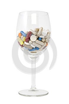 Glass of multicolored tablets and capsules