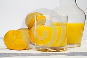 Glass of natural tangerine orange juice on white