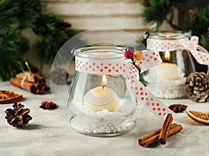 Glass New Year candle holders with candles on a wooden white table, selective focus