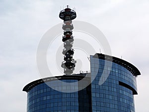 Glass office building with antenna at the top - color