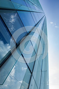 Glass office building with clouds reflection