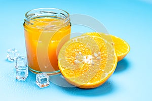 Glass of orange juice with sliced orange fruit and ice cubes