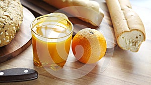 glass of orange juice and whole grain bread on table