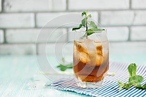 Glass of peach ice tea on wooden table.