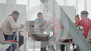 Through glass people sitting table boardroom. Colleagues meeting modern office.