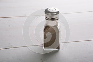 Glass pepper shaker on a wooden table