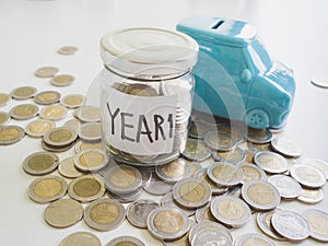 Glass Piggy bank and car bank with coins pile saving money in year one, Saving money for future plan and retirement fund concept