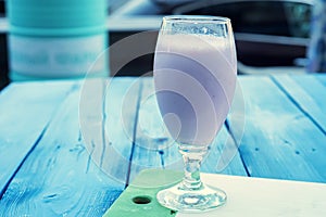 Glass of pink milk shake in outdoors restaurant