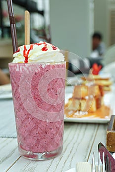A glass of pink multi berry smoothy in the cafe
