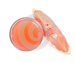 Glass of pink pomelo juice and fruit isolated on white, top view
