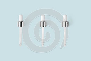 Glass pipettes on light blue minimalist pastel background. Concept skin care product