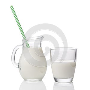 Glass and pitcher of milk with straw isolated on white background