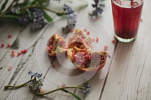 Glass of pomegranate juice with fresh fruits on wooden table