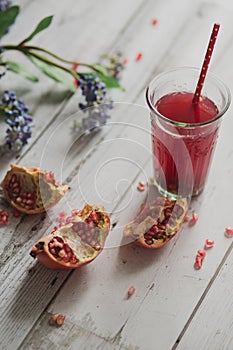Glass of pomegranate juice with fresh fruits on wooden table