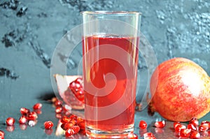 A glass of pomegranate juice with fresh pomegranate fruits on dark black background. Vitamins and minerals. Healthy