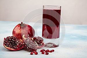 A glass of pomegranate juice with fresh pomegranate fruits on wooden table. Vitamins and minerals. Healthy drink concept