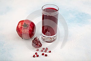 A glass of pomegranate juice with fresh pomegranate fruits on wooden table. Vitamins and minerals. Healthy drink concept