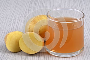 Glass of potato juice with its ingredients close-up on gray background