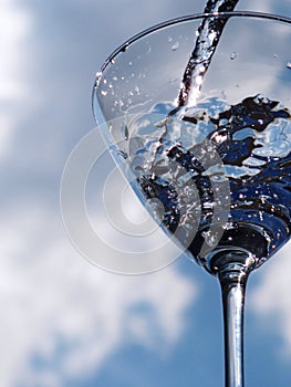 Glass of pouring water with reflection