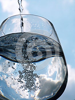 Glass of pouring water with reflection