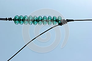 Glass powerline insulator disks against blue sky background