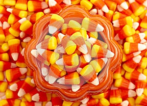 A Glass Pumpkin Decoration Filled to the Top and Overflowing with Classic Candy Corn
