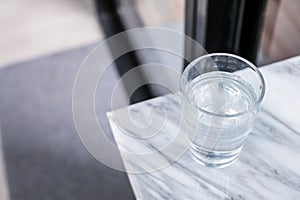 Glass of purified fresh drink water on marble table in cafe or coffee shop